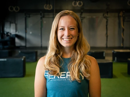 A woman in a blue t - shirt standing in a gym.