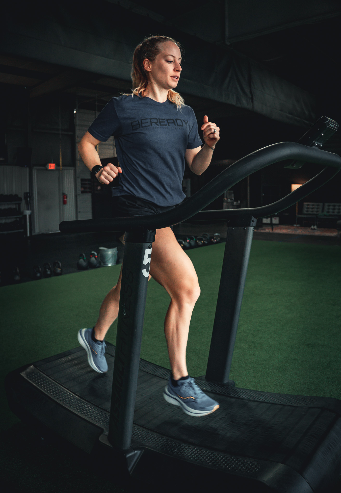 A woman running on a treadmill in a gym.
