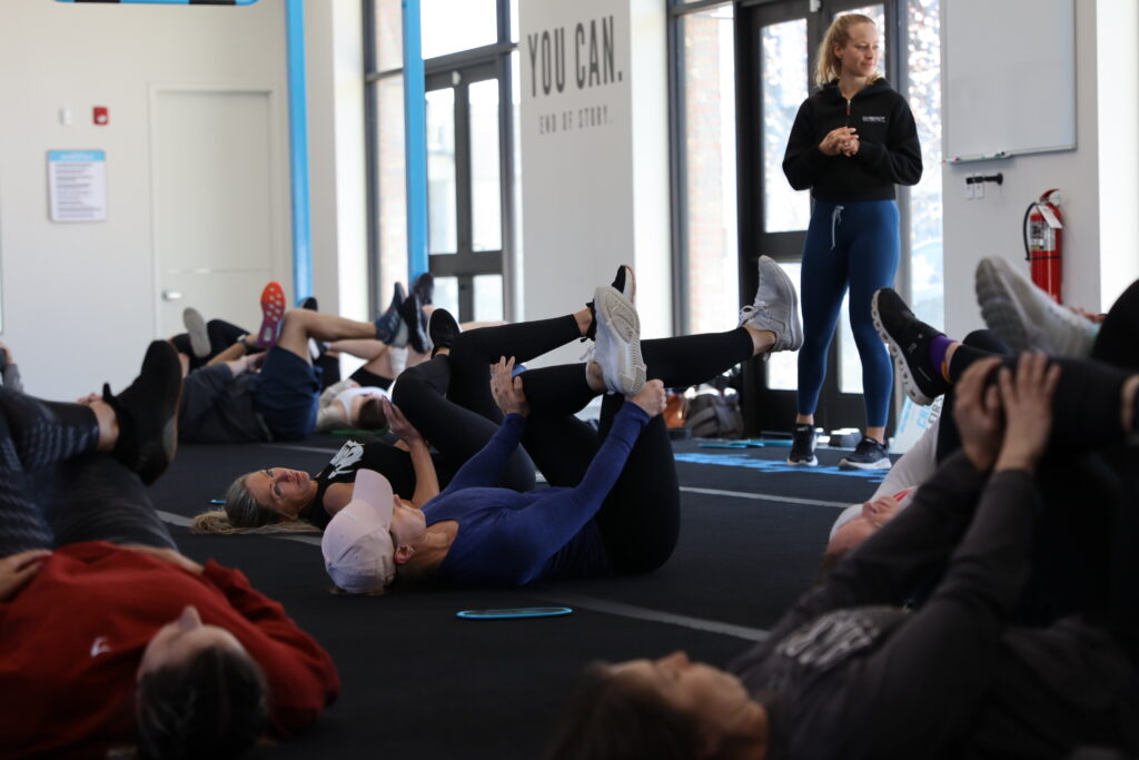 A group of people laying on the floor in a gym.